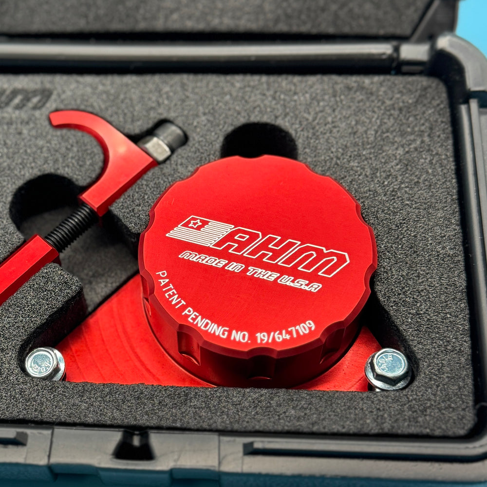 Close-up of red anodized locking disc engraved AHM Made in the U.S.A and patent pending number, in foam case.