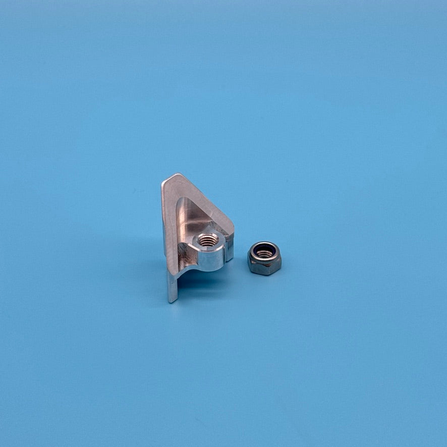 Angled view of raw aluminum Thule Helium Platform XT locking wedge, with threaded hole and curved base.
