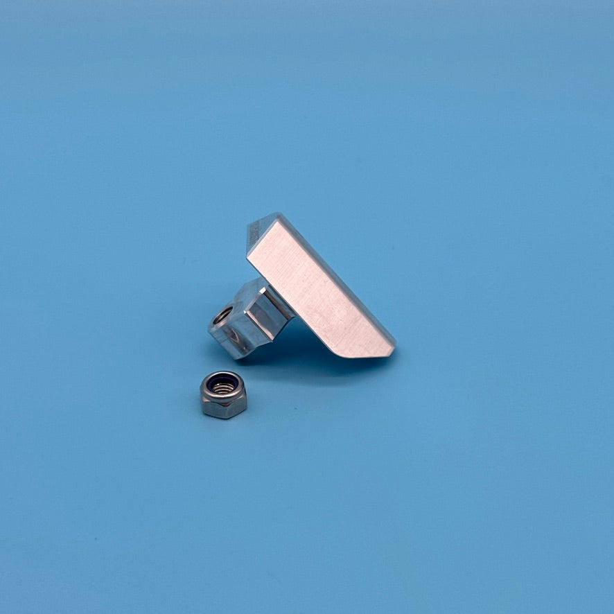 Raw aluminum Thule T2 locking wedge replacement, edge-on view showing angled clamping face, with lock nut.