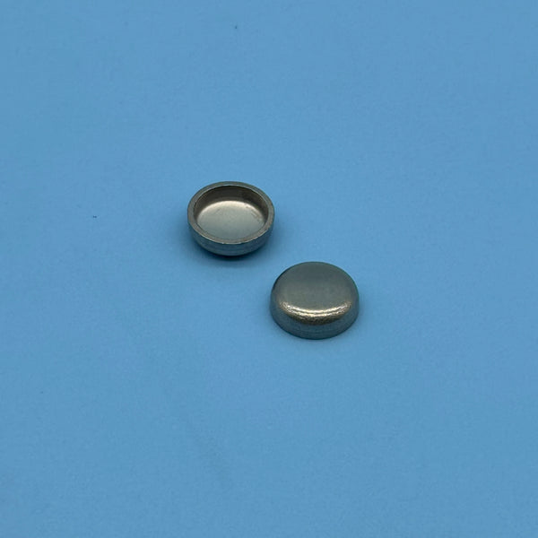 Two stainless steel cup-shaped sealing caps included with the Audi secondary air cleaning kit.