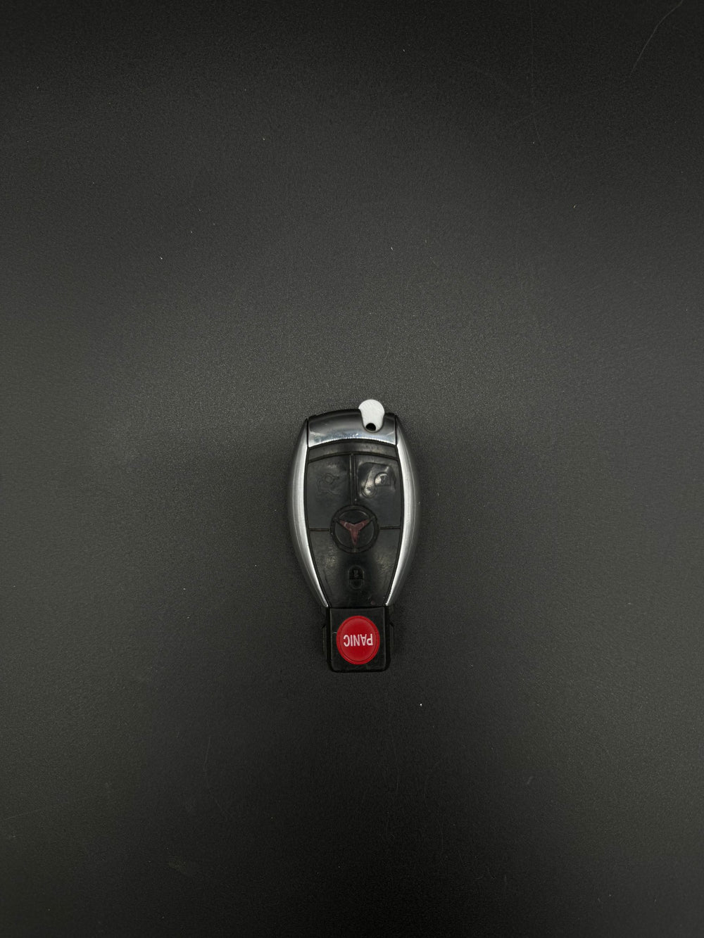 Mercedes-Benz smart keyfob front with red PANIC button and a white GEN-2 blade blank installed.