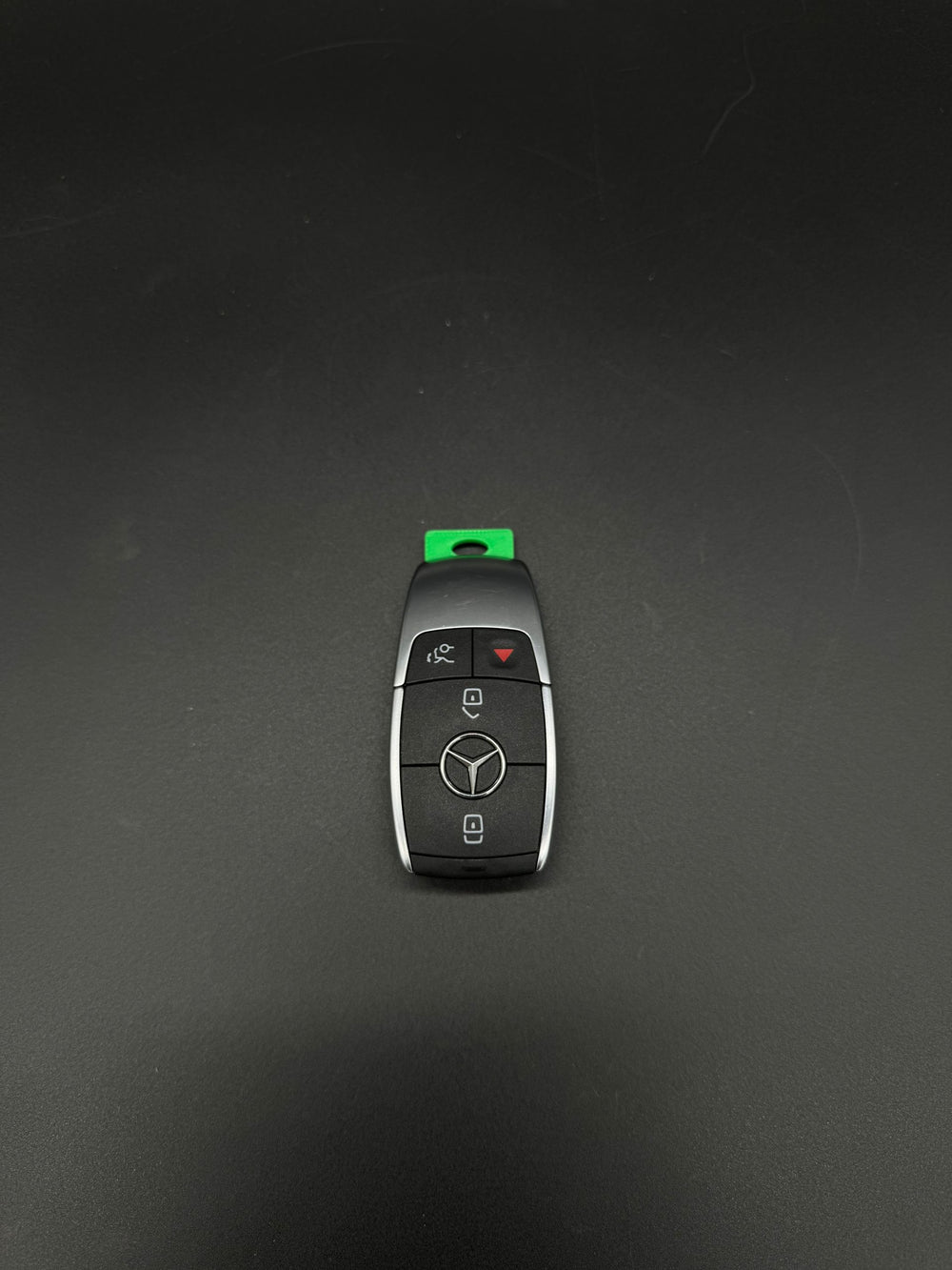 Newer-style Mercedes-Benz smart keyfob, button side, with a green GEN-3 blade blank (PN MBZ003) installed.