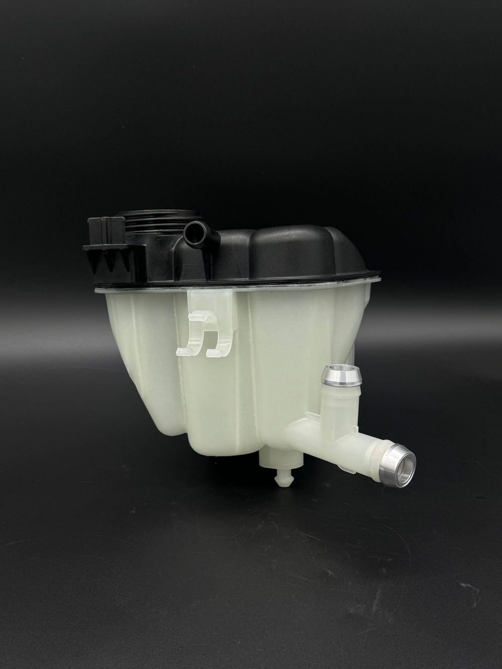 Mercedes ML/GL coolant expansion tank with bare aluminum CNC hose barb fittings installed, black background.