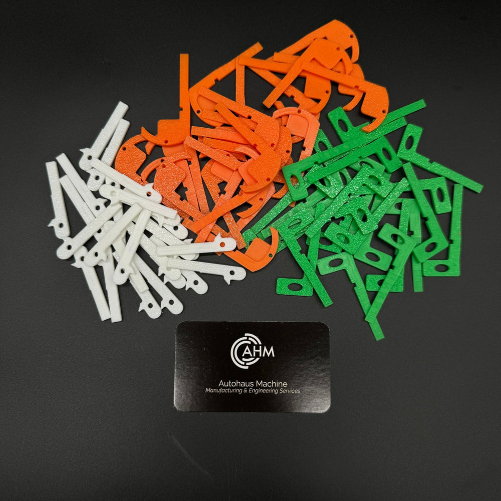 Assorted Mercedes key blanks in white, orange and green sorted in loose piles by generation.