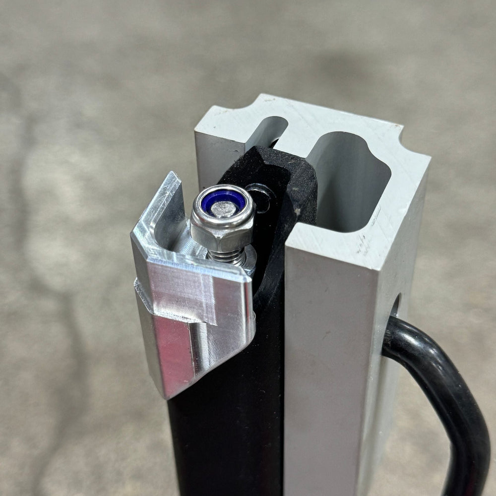 Aluminum locking wedge installed on a Thule Helium Platform XT rack arm with bolt and lock nut seated.