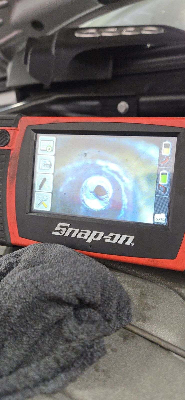Snap-on borescope screen showing a carbon-clogged Audi secondary air port before cleaning.