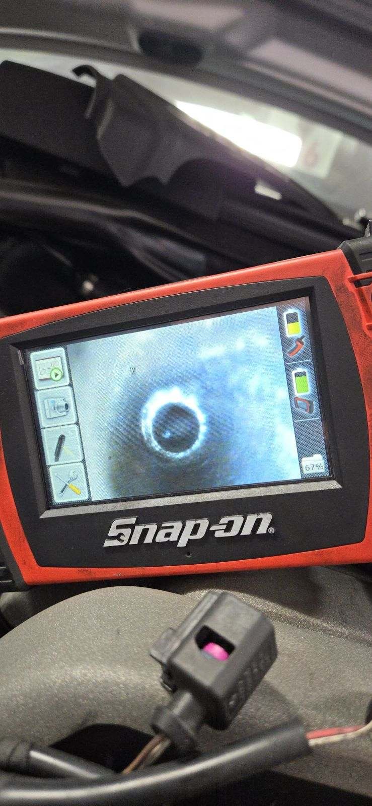 Snap-on borescope in the engine bay showing a cleared Audi secondary air port after cleaning.