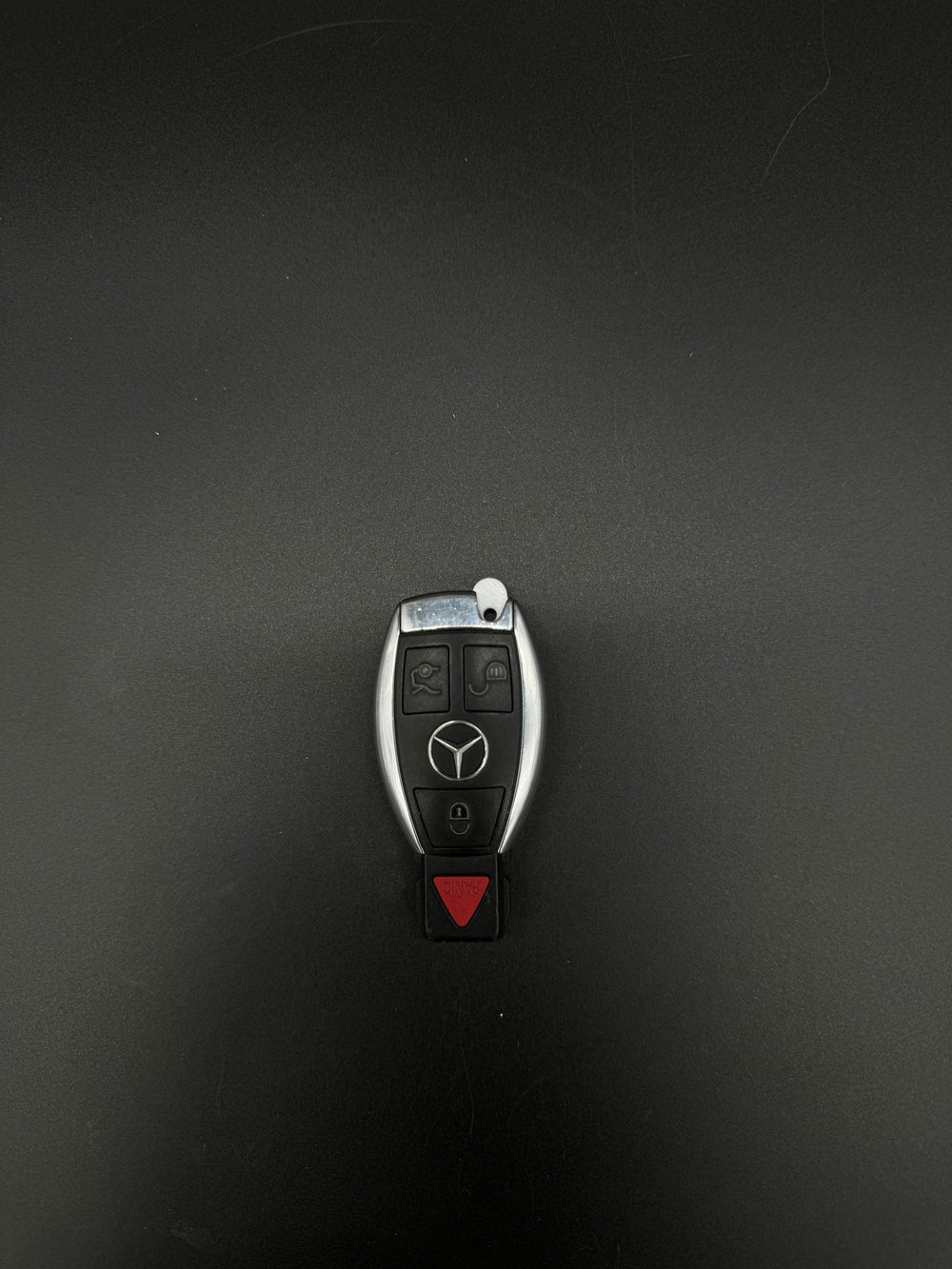 Mercedes-Benz smart keyfob, button side up with red panic button and white GEN-2 blade blank installed.
